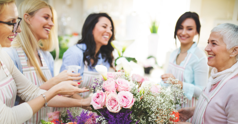 Women gathered around a table learning how to arrange flowers, one fo the spring fundraising ideas in the post.