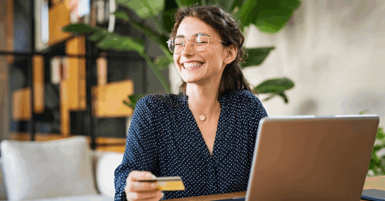 Woman smiles while taking out her credit card to fill out a giving form on an online fundraising platform.