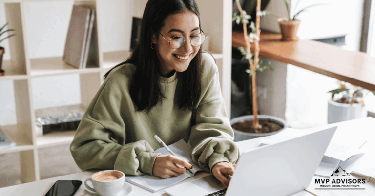 Woman smiles while using a computer to create a fundraising page.