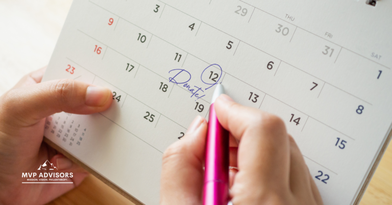 Blog header for article about monthly giving as a smart revenue strategy. Shows a pair of hands holding a calendar and a pen, with one date circled and the word "Donate!" on the same date.